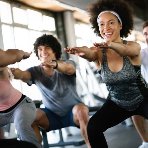 Group of happy fit people at the gym exercising
