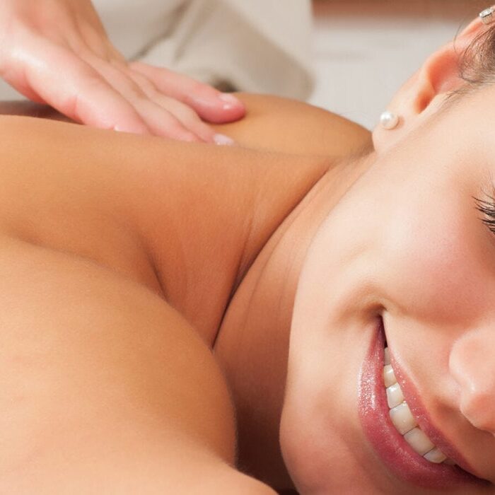 Girl getting back massage in massage salon, health spa.